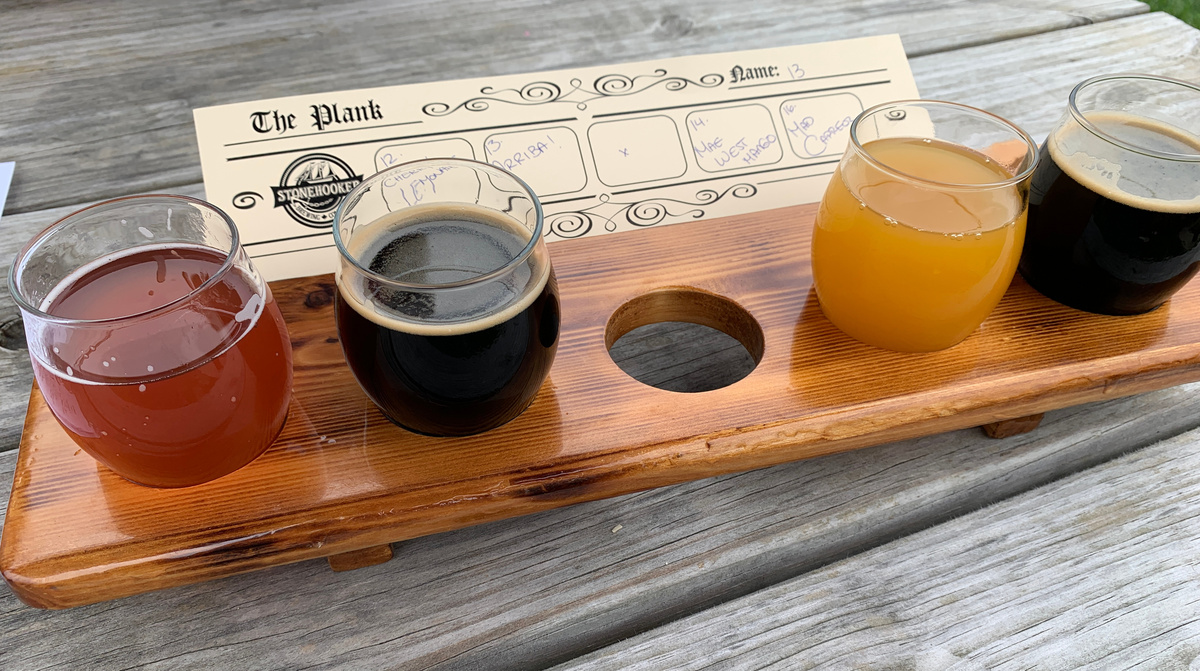 four small multi-hued beers in a board with holes