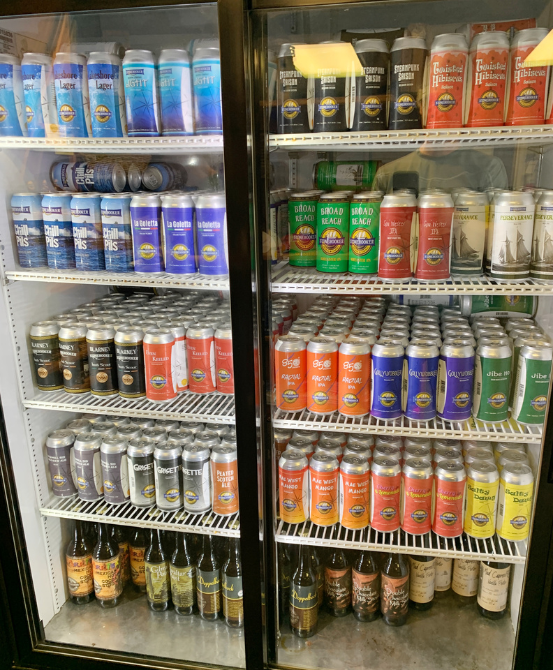 commercial glass-front fridge with many different beers on display